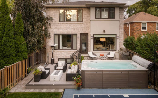 A multi-level deck with a spa and seating area.