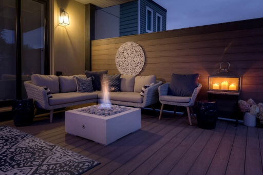 A seating area on a deck with a privacy wall.