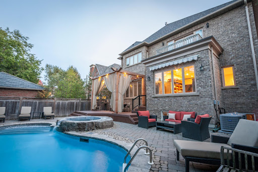 A backyard with an inground pool and hot tub.