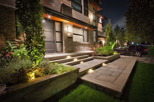 Stone steps leading up to the front entrance of a house, with recessed stair lighting.