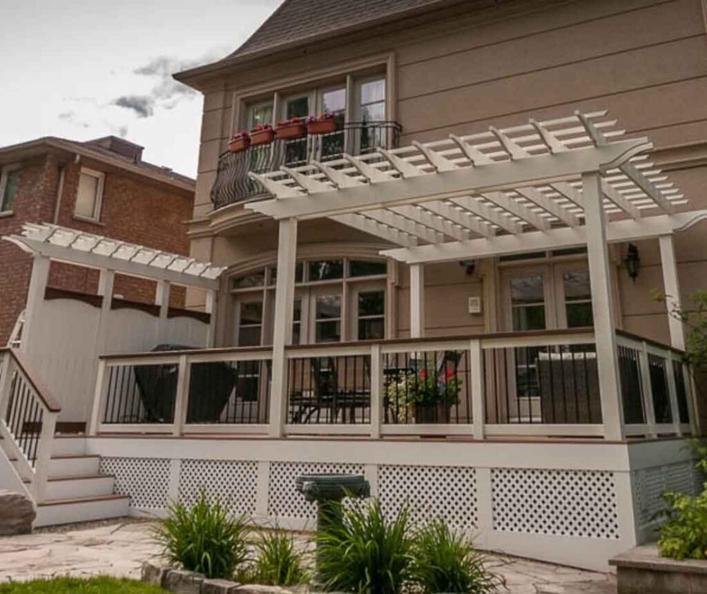 Classic white pergola over a painted deck with matching vertical posts, rafters, and purlins