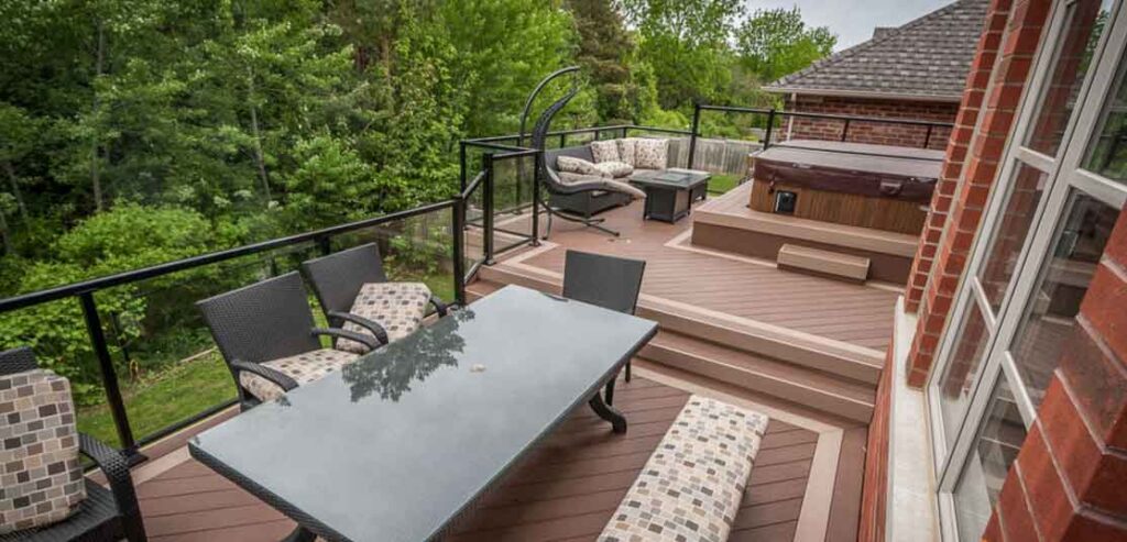Multi-level second-floor deck with hot tub overlooking a wooded ravine