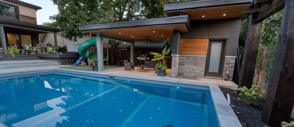 Modern home with a matching backyard design featuring a pool, roof overhang, and a private pool cabana seating area