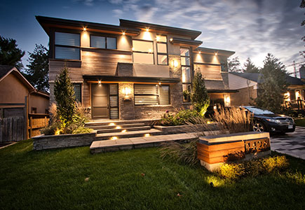 Modern front yard in Mississauga with multi-landing Banas stone porch, columnar tree planters, artistic stone driveway, and architectural lighting.