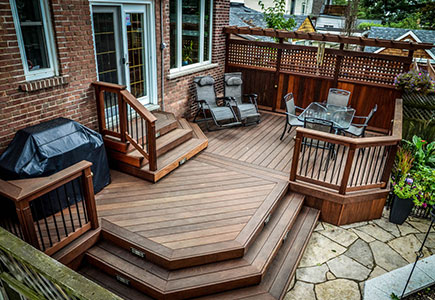 Ipe hardwood deck with classic cut corners, privacy screens, and traditional styling, blending with existing flagstone landscaping.