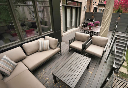 Walkout Fiberon deck in North York with glass railings, privacy screens, and evening lighting