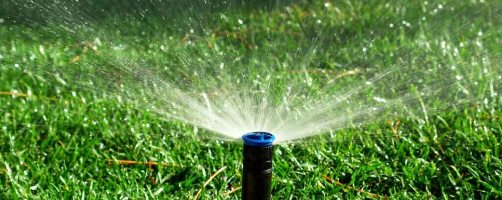 Automatic sprinkler system irrigating a lawn for consistent, worry-free watering.