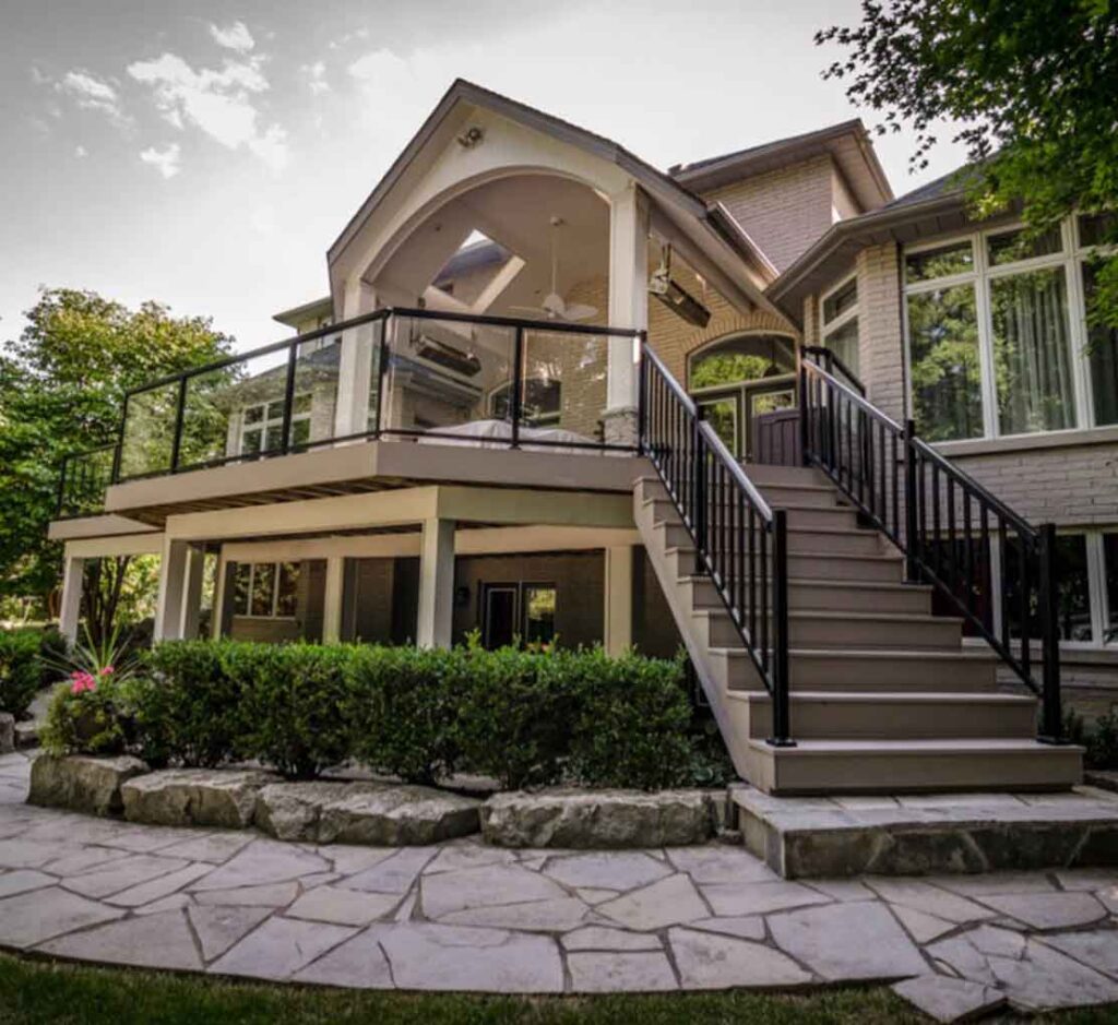 Second-floor PVC deck off the main floor in Mississauga with a roof cover and outdoor kitchen, integrated into the backyard for low-maintenance, carefree outdoor living