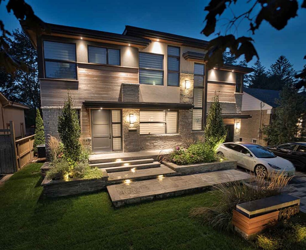 Modern front yard design with clean lines that match the home’s architecture, featuring structured landscaping and subtle evening lighting that creates a bold, welcoming statement.
