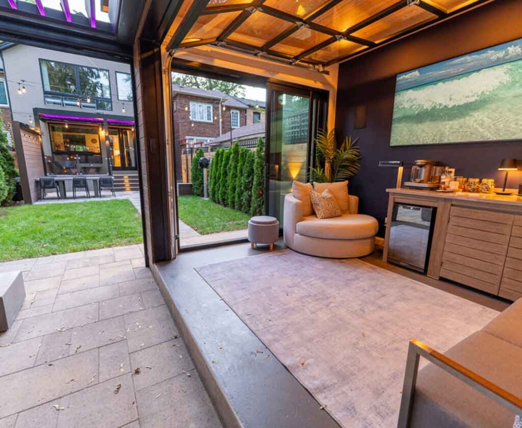 Fully furnished pavilion with bar, fridge, heaters, and comfortable seating, seamlessly connected to a louvered pergola to expand and enhance the outdoor living space.