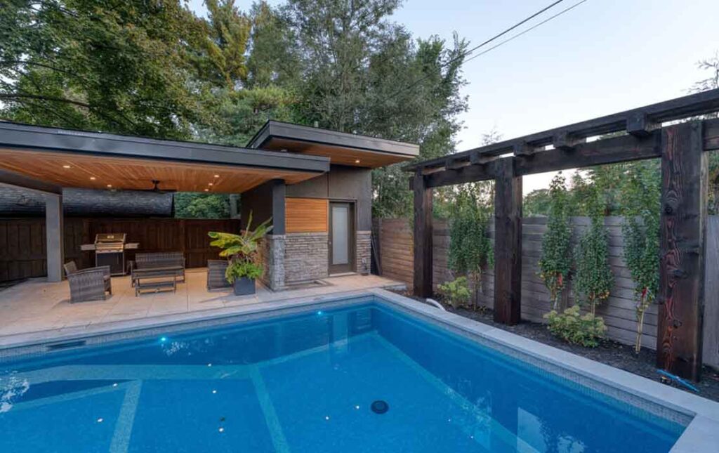Poolside pavilion providing shaded relaxation beside the water, featuring an attached washroom and outdoor shower for convenient poolside use.