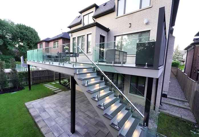 Second floor PVC deck with frameless glass railings, lighting, and multi-level walkout design