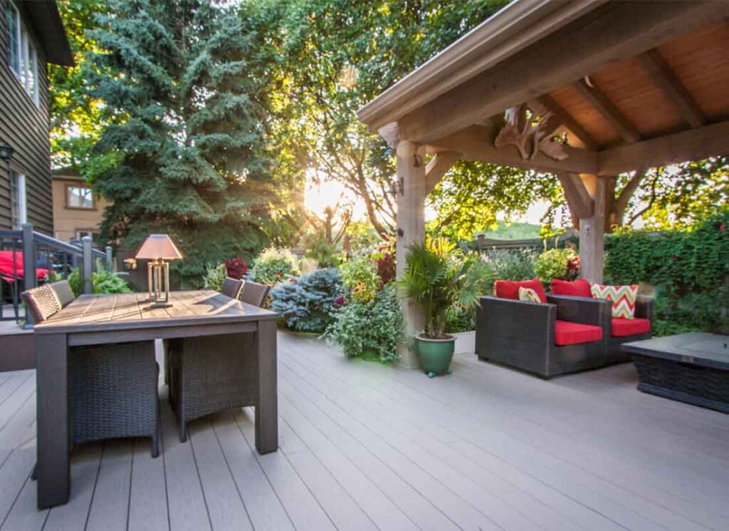 Timber gazebo on a PVC deck in an Etobicoke backyard, surrounded by lush greenery, providing protection from sun and rain