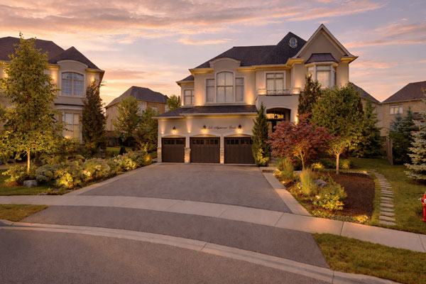 Asphalt driveway widened with extension, planting beds, and built-in landscape lighting.