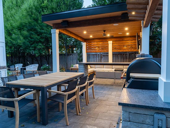 Modern backyard landscaping with outdoor kitchen, arbour, and cabana for a resort-style staycation