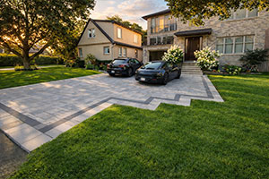 Etobicoke front yard landscaping with large interlocking driveway and modern design aesthetic.