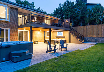 Deck with stone patio below and walkout basement creating extended outdoor living space