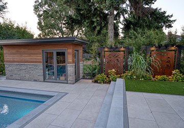 Modern backyard paved with large-format ceramic tiles around a swimming pool