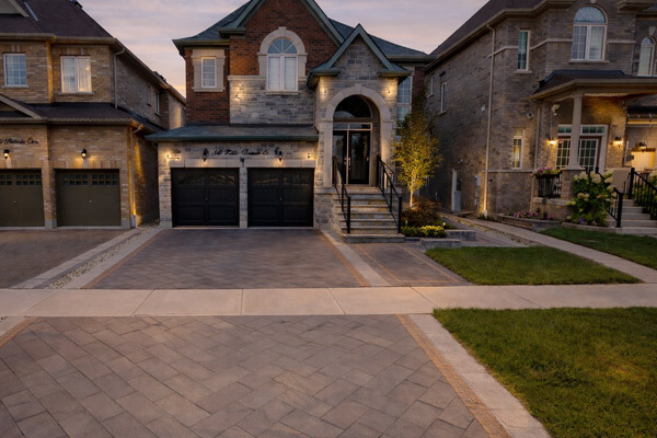 Contemporary interlock driveway extension paired with a natural stone front porch and clean architectural lines.
