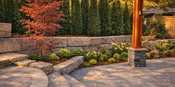 Backyard landscaping with armour stone retaining walls and integrated planting creating a functional and visual focal feature