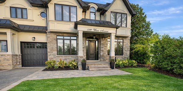 Oakville front yard landscaping with natural stone covered porch and raised garden beds on both sides
