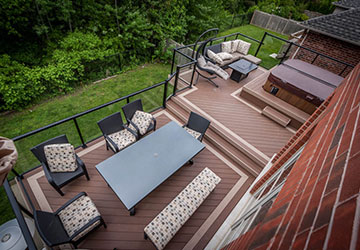 Elevated multi-level PVC deck designed for entertaining with dining space and ravine views