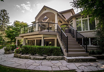 econd-floor deck with covered roof, basement walkout seating area, and surrounding landscape design