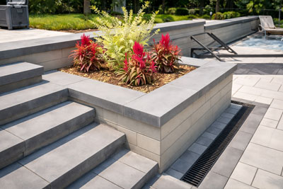 Precast concrete block retaining walls seamlessly integrated with matching concrete steps in a modern Toronto backyard