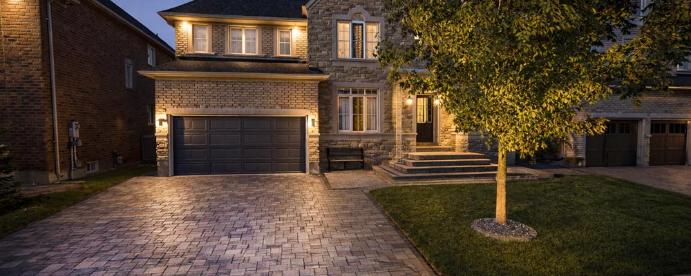 Luxury Unilock driveway on concrete base with natural stone front porch and steps at Brampton residence