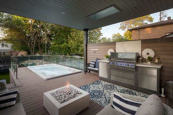 Composite deck in The Beaches Toronto with built-in swim spa, roof cover at the house and outdoor kitchen