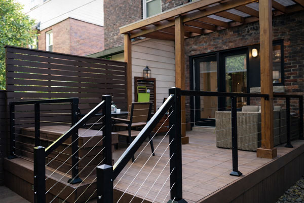 Luxury composite deck built for a narrow downtown Toronto backyard with polycarbonate pergola and cable railings