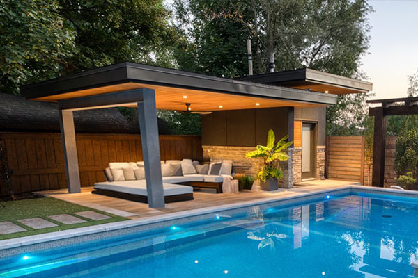 Modern pool cabana outdoor structure with lounge seating and change room beside swimming pool