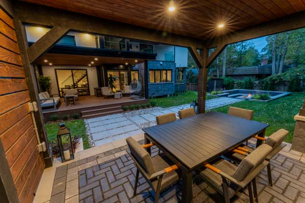 Mississauga modern backyard with elevated covered seating areas and a sunken firepit